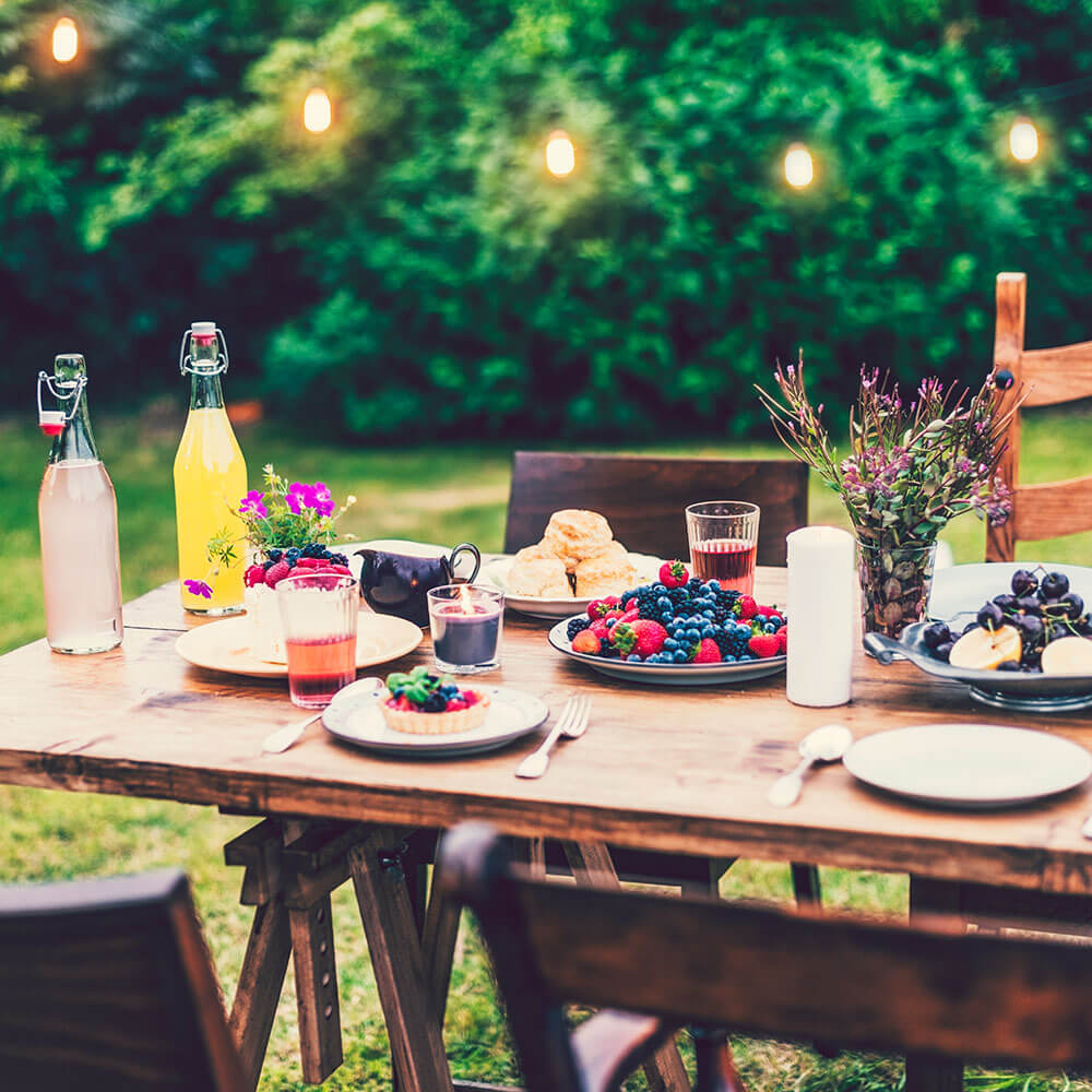 Summer table setting with juices, fresh fruit and wooden table 